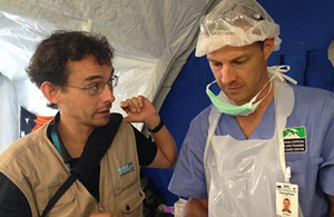 A volunteer talking to a man in surgical scrubs. 