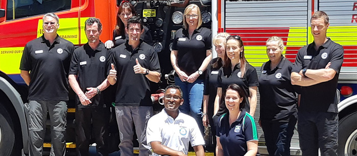 A group of NZMAT volunteers posed in front of a fire truck. 
