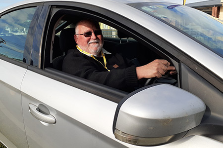 Photo of one of the Cancer Society client drivers in his car. 