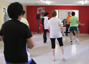 A group of people doing zumba exercises. 