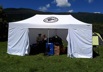 Volunteers with supplies in an NZMAT gazebo facility. 