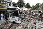  Photo of a truck next to a pile of rubble. The roof of the truck has collapse under some of the rubble.