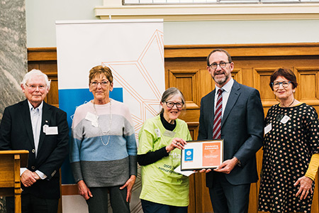 Photo of four Samaritans Telephone Helpline volunteers accepting the award from Minister Little. 