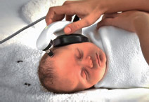Photo of a sleeping baby, with the ear cushion being placed on its head. 