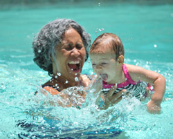 A grandmother playing with their granddaughter at the pool. 
