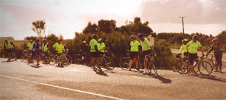 Photo of a big group of road cyclists, wearing matching outfits. 
