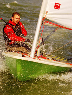 A man sailing a small boat. 