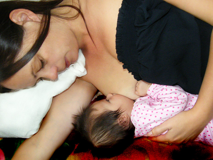 Breastfeeding mother with baby - lying down hold