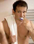 Photo of a young man brushing his teth in the morning.