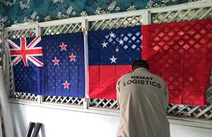 A logistics volunteer, by the NZ and Samoan flags.