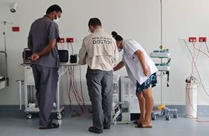 An NZ doctor and two other workers with medical equipment.