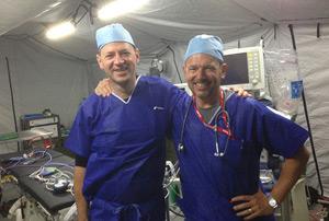 Two volunteers wearing scrubs on deployment.